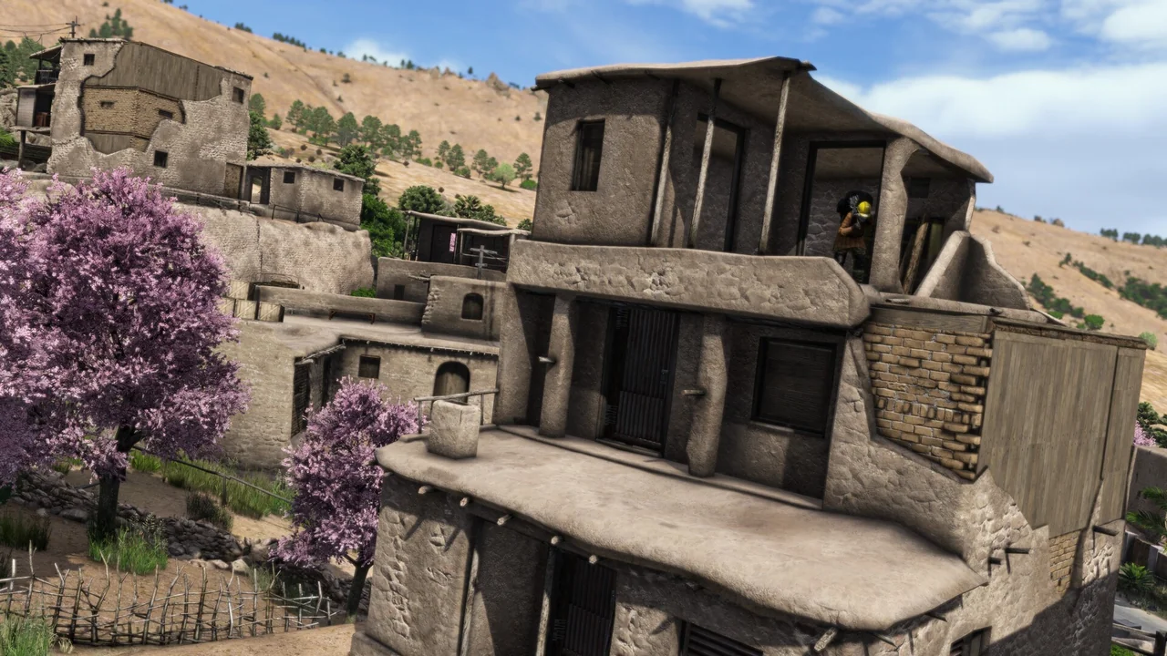 Mud brick houses stacked up a Nasdara hillside with exposed brickwork